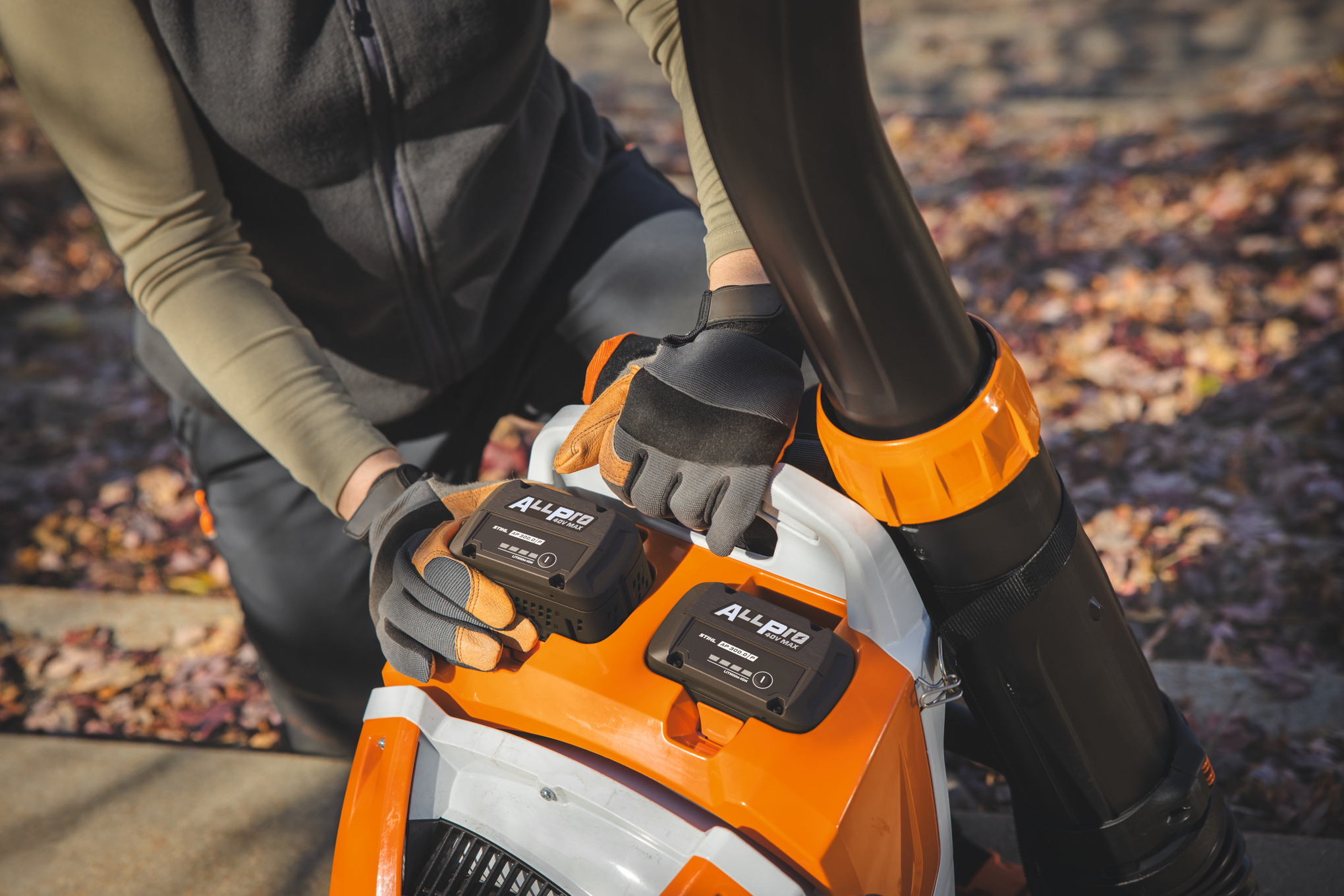 Un peisagist profesionist introduce a doua baterie STIHL AP 300.0 P în suflanta cu rucsac alimentată cu baterie STIHL