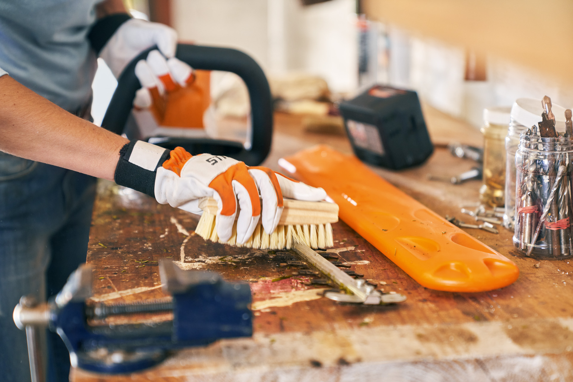 Întreținerea utilajelor: foarfeca de tuns garduri vii cu acumulator STIHL HSA 56 este curățată cu o perie