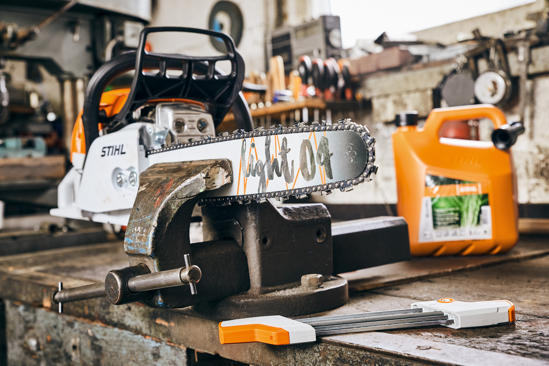 Motoferăstrău pe benzină STIHL MS 261 C-M cu șină port-lanț Light 04 lângă amestecul de combustibil STIHL MotoMix înainte de ascuțire