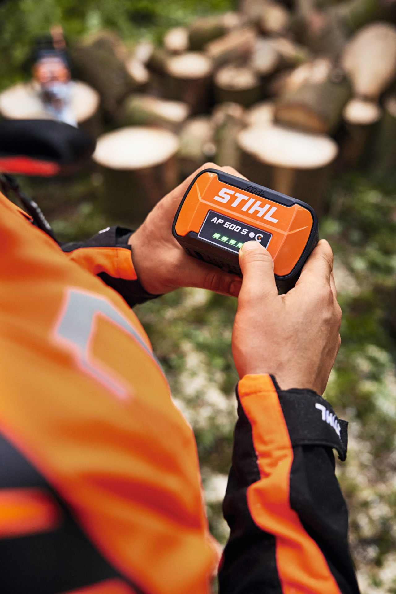 Prim-plan al unei persoane care ține în mână acumulatorul litiu-ion STIHL AP 500 S