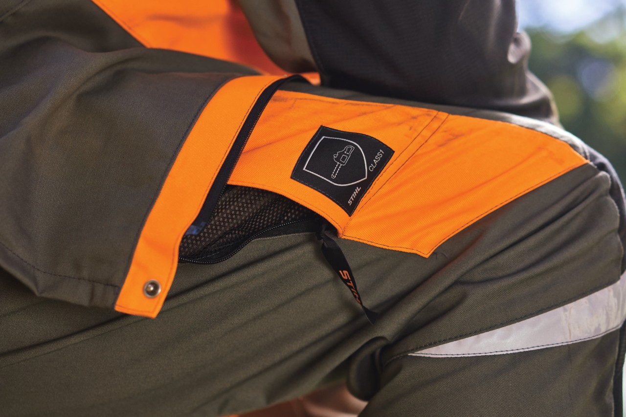 Pantaloni de protecție împotriva tăierii STIHL gri și portocaliu cu pictogramă sub formă de motoferăstrău pentru clasa de protecție împotriva tăierii 1