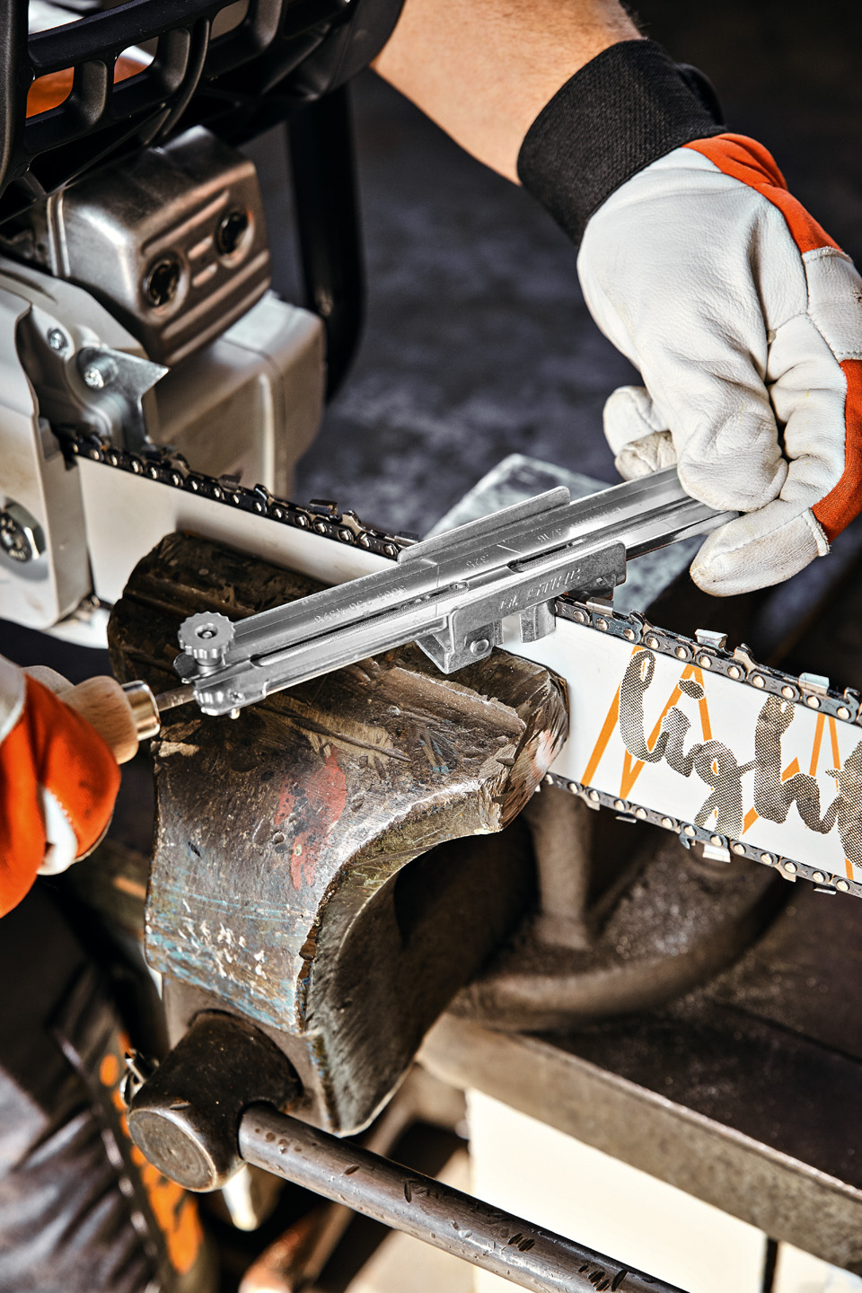 O persoană cu un ghidaj pentru suportul de pilă STIHL pe o șină port-lanț STIHL Light 04