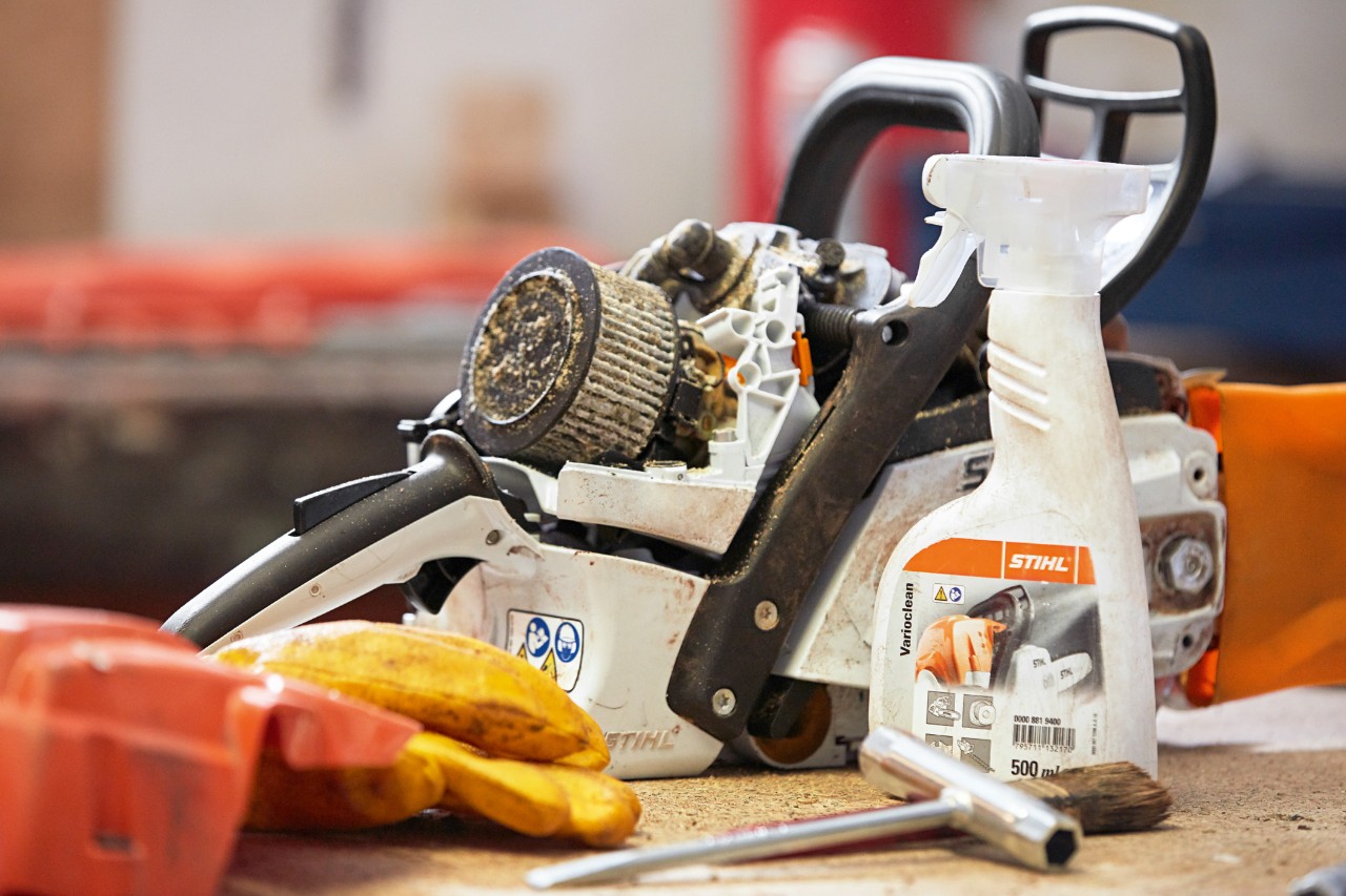 Detergentul STIHL Varioclean lângă motoferăstrăul STIHL pe bancul de lucru