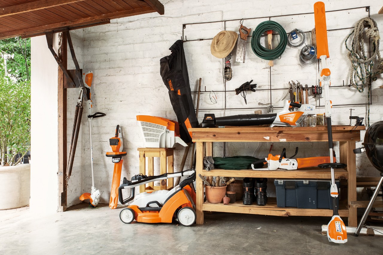 Motocoasa cu acumulator STIHL FSA 56 este depozitată în poziție suspendată, lângă aceasta se află foarfeca de tuns garduri vii cu acumulator HSA 56 și HLA 56 și mașina de tuns iarba cu acumulator RMA 339