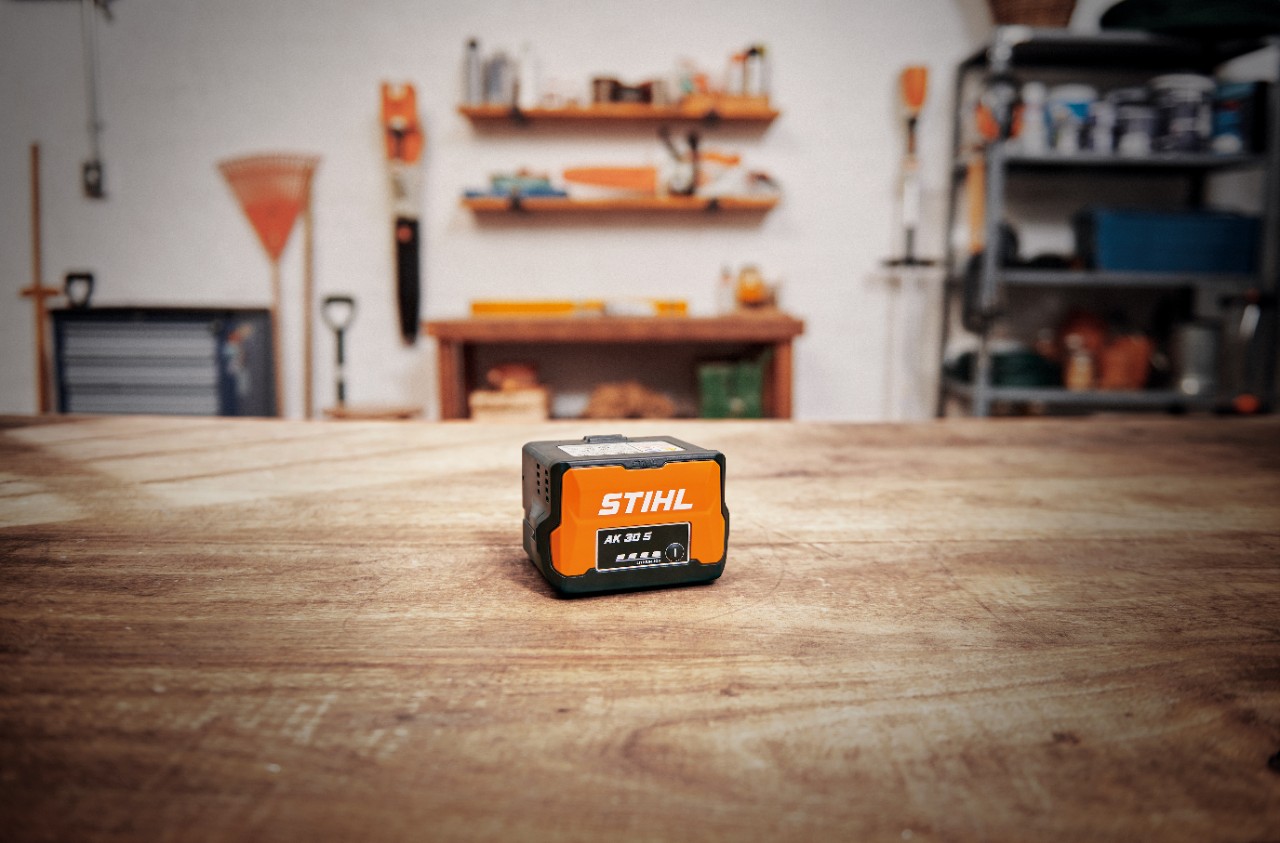 Atelier cu un acumulator STIHL AK 30 S pe o masă de lemn 