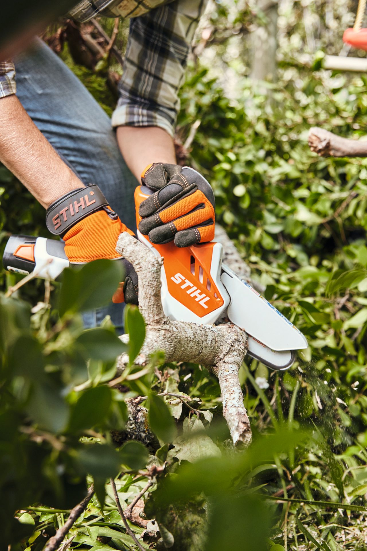 Lemnul unui gard viu este tăiat cu ajutorul utilajului de tăiat material lemnos cu acumulator STIHL GTA 26